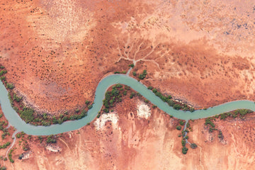 Jade Ribbon, aerial photograph of a turquoise tidal creek winding through red flats in Exmouth Gulf