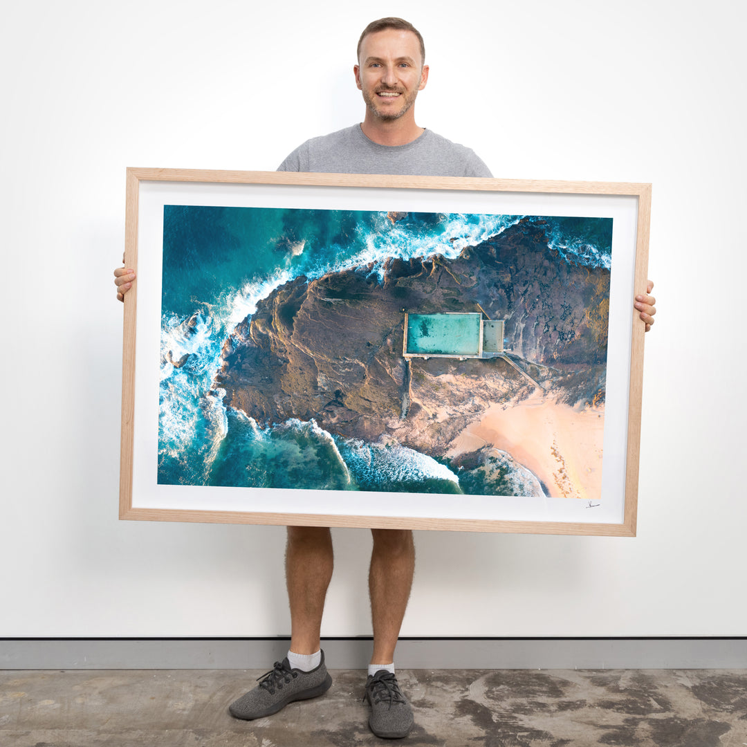 Vincent Rommelaere holding a framed print of Mona Vale Rock Pool - Australia Unseen